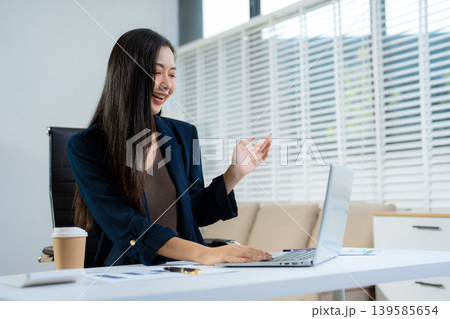 Businessman using laptop computer and smartphone in office. Happy woman, entrepreneur, small business owner working online. 139585654