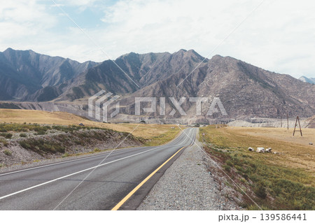 Scenic Chuysky Trakt highway through Altai Mountains valley under cloudy sky 139586441