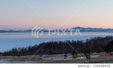 Winter sunset over Lake Baikal ice and distant mountains in Maloye More strait Winter sunset over Lake Baikal ice and distant mountains in Maloye More strait 139586458