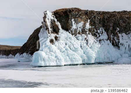 Frozen cliff with blue ice formations on Lake Baikal winter shoreline landscape Frozen cliff with blue ice formations on Lake Baikal winter shoreline landscape 139586462
