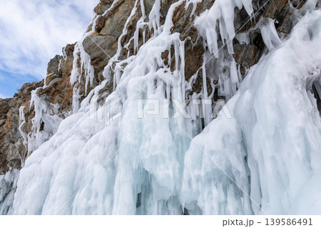 Frozen cliff with icicles and snow on the shore of Lake Baikal in winter Frozen cliff with icicles and snow on the shore of Lake Baikal in winter 139586491