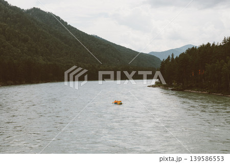 Rafting on mountain river in Altai, small boat on water between forest hills 139586553