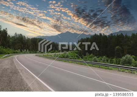 Scenic mountain road in Altai with forest and dramatic sunset sky panorama 139586555