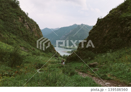 Scenic mountain valley trail with river view in Altai, hikers in summer Scenic mountain valley trail with river view in Altai, hikers in summer 139586560