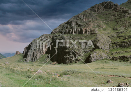Rocky mountain cliff and green valley landscape in the Altai Mountains at dusk Rocky mountain cliff and green valley landscape in the Altai Mountains at dusk 139586595