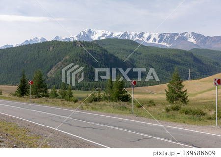 Scenic highway curve with Altai Mountains and snowy peaks in the distance Scenic highway curve with Altai Mountains and snowy peaks in the distance 139586609