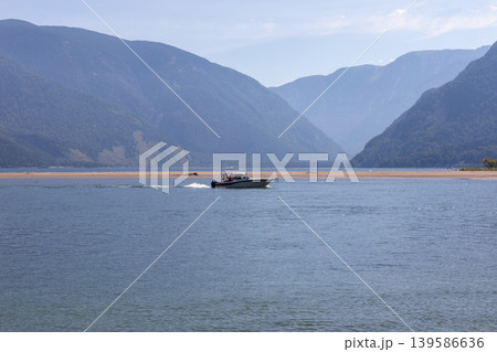 Motorboat cruising on Lake Teletskoye with mountain landscape in Altai Motorboat cruising on Lake Teletskoye with mountain landscape in Altai 139586636
