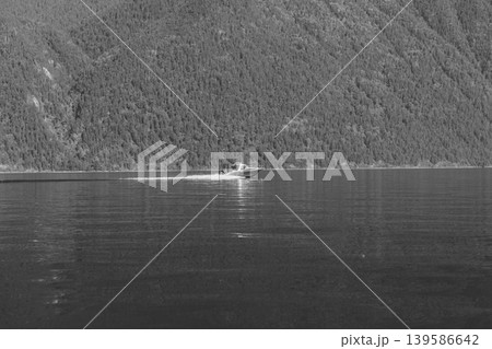 Speedboat cruising on Lake Teletskoye with forested Altai mountains in summer Speedboat cruising on Lake Teletskoye with forested Altai mountains in summer 139586642