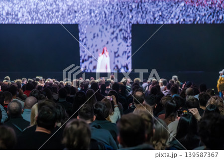 Large concert audience watching stage performance and recording live music with smartphones 139587367