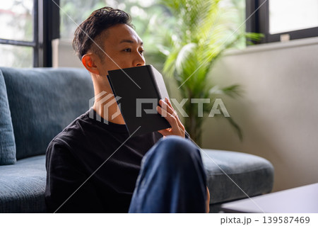 ソファで本を読む男性 ソファで本を読む男性 139587469