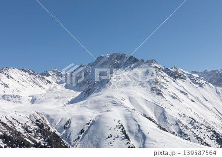Snowy mountain peaks above Karakol ski resort in winter, Kyrgyzstan landscape Snowy mountain peaks above Karakol ski resort in winter, Kyrgyzstan landscape 139587564