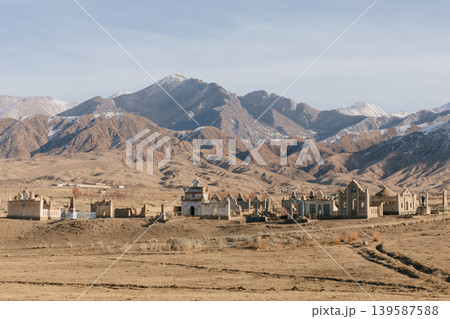 Rural cemetery with mausoleums in Kyrgyzstan mountains under winter sky 139587588