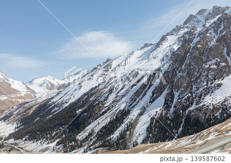 Snowy mountain landscape in Barskoon Gorge with rocky peaks and blue sky Snowy mountain landscape in Barskoon Gorge with rocky peaks and blue sky 139587602
