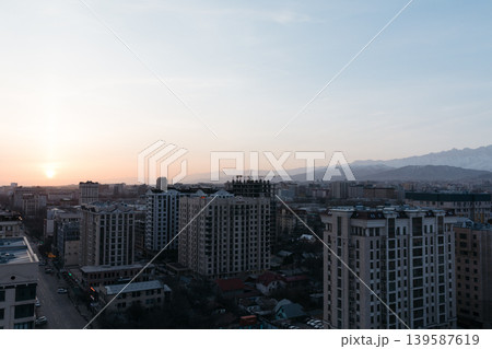 Sunset skyline of Bishkek with modern apartment buildings and distant mountains 139587619