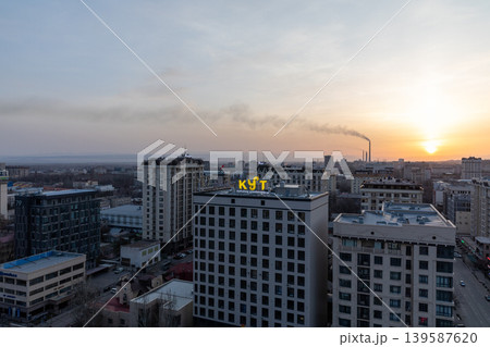 Bishkek city skyline at sunset with modern buildings and industrial smoke plume Bishkek city skyline at sunset with modern buildings and industrial smoke plume 139587620