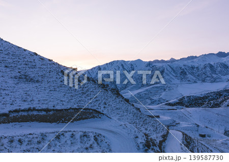 Chunkurchak Valley winter mountain landscape with snowy road at sunrise, Kyrgyzstan Chunkurchak Valley winter mountain landscape with snowy road at sunrise, Kyrgyzstan 139587730