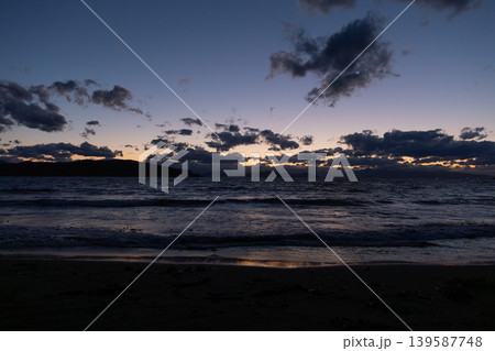 Dramatic twilight seascape with dark clouds and waves on a quiet beach 139587748