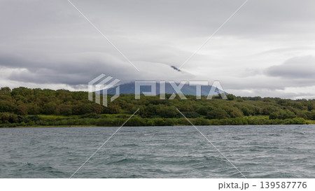 Cloudy view of Kuril Lake with forest shoreline and volcano, Kamchatka Cloudy view of Kuril Lake with forest shoreline and volcano, Kamchatka 139587776