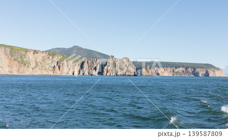 Rocky sea cliffs and volcanic coastline landscape in Kamchatka at sunny day Rocky sea cliffs and volcanic coastline landscape in Kamchatka at sunny day 139587809