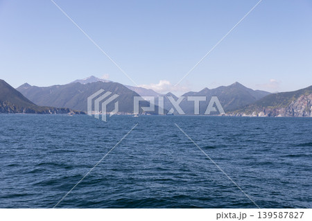 Coastal mountains and calm sea horizon in Kamchatka Peninsula landscape, Russia Coastal mountains and calm sea horizon in Kamchatka Peninsula landscape, Russia 139587827