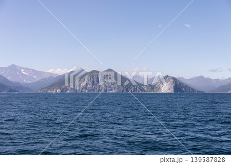 Coastal mountains and rocky cliffs across the Pacific Ocean in Kamchatka Coastal mountains and rocky cliffs across the Pacific Ocean in Kamchatka 139587828