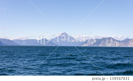 Volcano and mountain range across the Pacific Ocean seascape in Kamchatka Volcano and mountain range across the Pacific Ocean seascape in Kamchatka 139587831