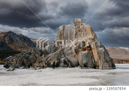 Dramatic rocky cliff on frozen Lake Baikal under storm clouds in winter 139587854