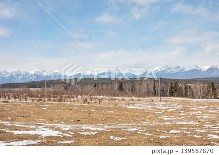 Spring steppe landscape with snow patches and distant mountains in Buryatia 139587870