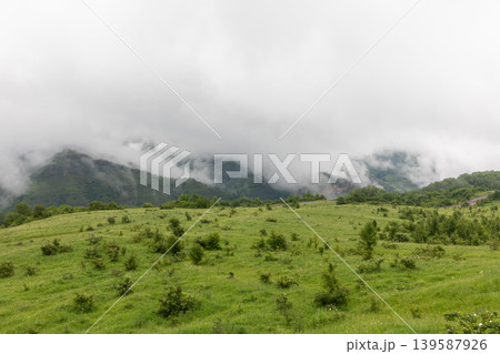 Misty mountain meadow landscape in Dagestan with low clouds and green hills Misty mountain meadow landscape in Dagestan with low clouds and green hills 139587926