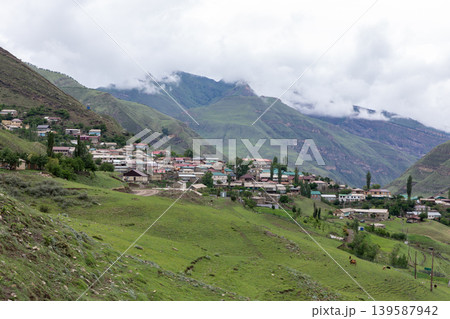 Mountain village in Dagestan with green valley and cloudy Caucasus peaks Mountain village in Dagestan with green valley and cloudy Caucasus peaks 139587942