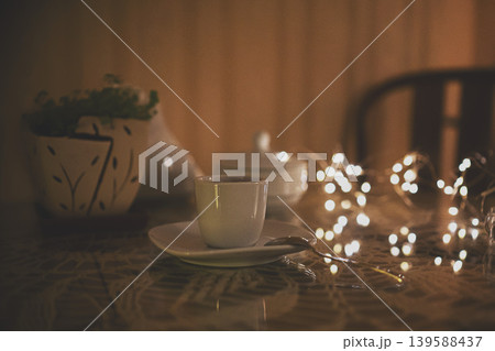 Autumn coffee cup on wooden table, cozy warm sunset light and lights in background 139588437