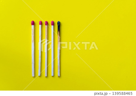 Success, defeat, achievement. The concept of happiness. Matches on a yellow background. Burnt dark match among normal matches. Burning match fire to its neighbors, a metaphor for ideas and inspiration Success, defeat, achievement. The concept of happiness. Matches on a yellow background. Burnt dark match among normal matches. Burning match fire to its neighbors, a metaphor for ideas and inspiration 139588465