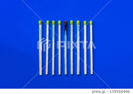Success, defeat, achievement. The concept of happiness. Matches on a yellow background. Burnt dark match among normal matches. Burning match fire to its neighbors, a metaphor for ideas and inspiration 139588466