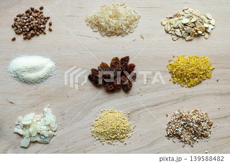 Assorted cereal grain porridge seeds set on a wooden background: buckwheat, rice, semolina, wheat, couscous, oatmeal Assorted cereal grain porridge seeds set on a wooden background: buckwheat, rice, semolina, wheat, couscous, oatmeal 139588482