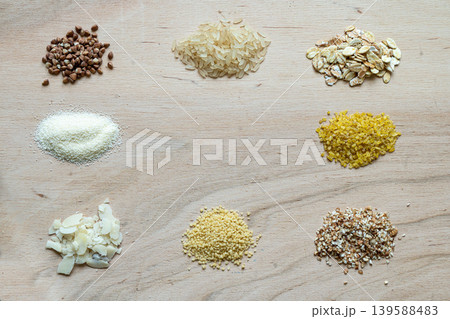Assorted cereal grain porridge seeds set on a wooden background: buckwheat, rice, semolina, wheat, couscous, oatmeal 139588483