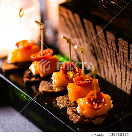 Pumpernickel bread sandwich snack with cured smoked salmon and fresh avocado served as close-up on a wooden cutting board 139588536