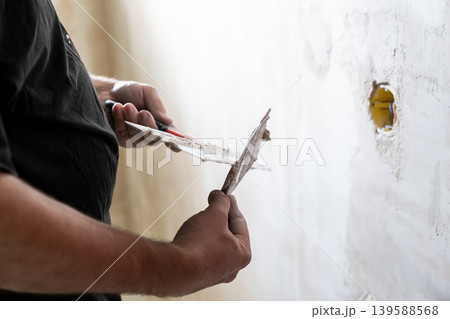 Happy worker man making wall in the room by hand spatula repair 139588568