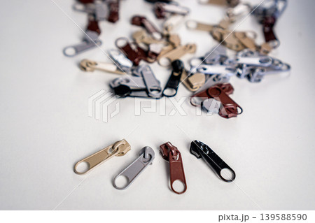 Metal zipper slide isolated on white. Assortment of zipper slides. Clothing element. Metal zipper slide isolated on white. Assortment of zipper slides. Clothing element. 139588590