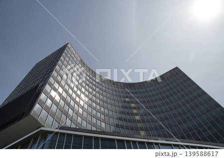 Modern curved building with curved facade and horizontal stripe design against the sky. 139588617