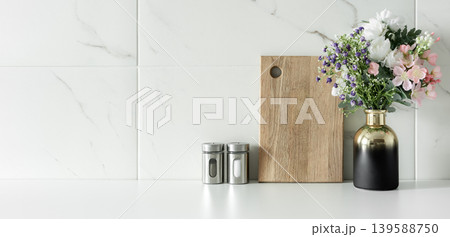 Minimal kitchen counter with flowers and wooden cutting board Minimal kitchen counter with flowers and wooden cutting board 139588750