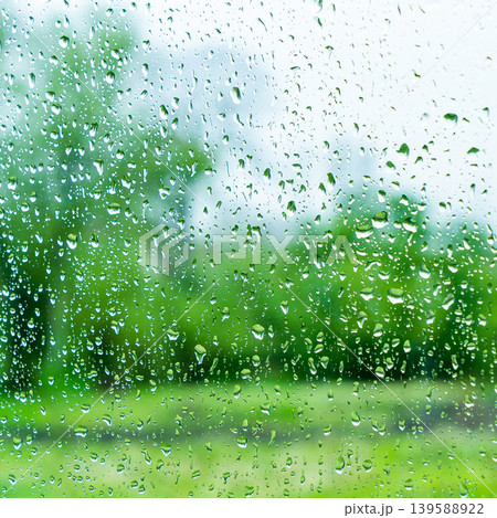 A rainy day window view. Rain drops on window. Condensed rain drop on the car glass window on a rainy day. Dew moisture condensation on wet mirror background. Fresh weather. Water raindrop bg 139588922