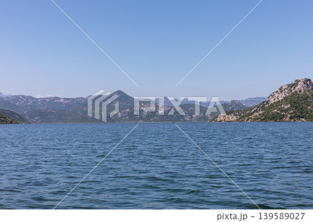 Scenic view of Lake Skadar with mountain shoreline and clear blue sky panorama Scenic view of Lake Skadar with mountain shoreline and clear blue sky panorama 139589027