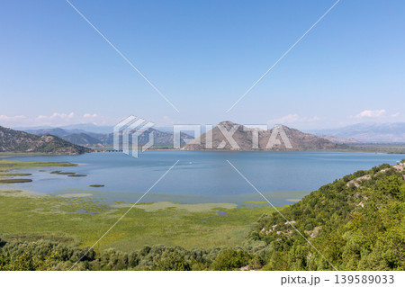 Panoramic view of Lake Skadar wetlands and mountains under clear blue sky 139589033