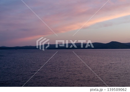 Lake Turgoyak sunset panorama with calm water and distant Ural Mountains Lake Turgoyak sunset panorama with calm water and distant Ural Mountains 139589062