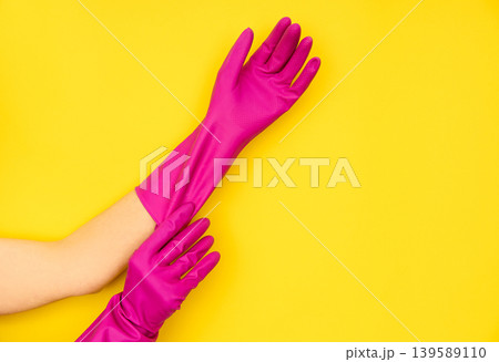 Person putting on pink rubber cleaning gloves 139589110