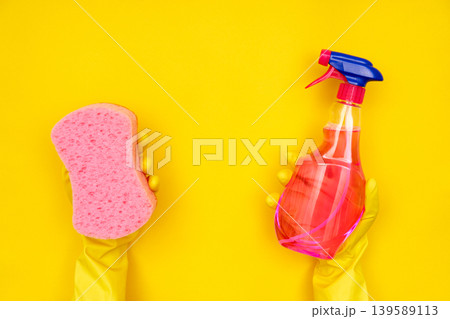 Hands in yellow gloves holding sponge and spray Hands in yellow gloves holding sponge and spray 139589113