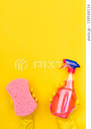 Hands in yellow gloves holding sponge and spray Hands in yellow gloves holding sponge and spray 139589114