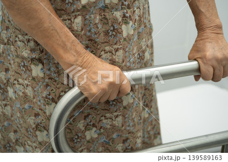 Asian elderly woman patient use handrail safety in toilet support rail in bathroom. 139589163