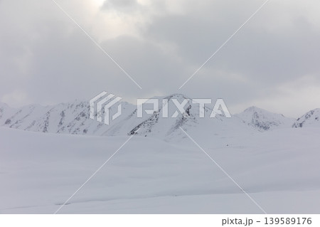 Snowy mountain landscape at Ala-Bel Pass with cloudy winter sky, Kyrgyzstan 139589176