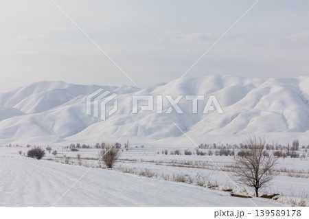 Snowy winter landscape with rolling mountains near Toktogul, Kyrgyzstan 139589178
